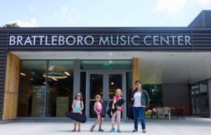 children with instruments outside building